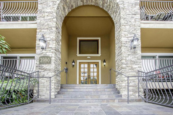 Front view of a building entrance with stone accents and double doors.