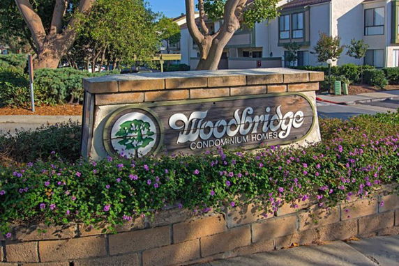 Front view of condominiums with a sign reading 'Woodbridge Condominium Homes'.