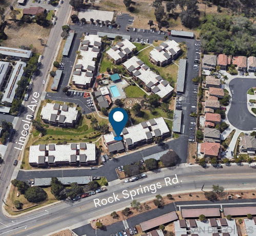 Aerial view of a residential complex with multiple buildings and a swimming pool.