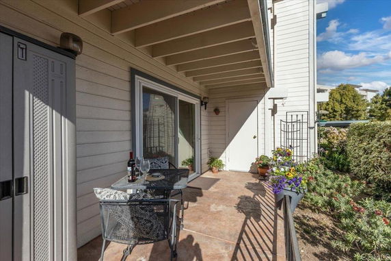 Front view of a house with a small patio area featuring a table and chairs.