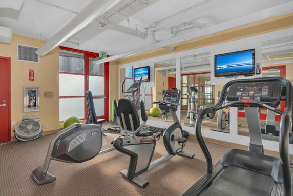 Indoor gym with exercise equipment including treadmills and stationary bikes.