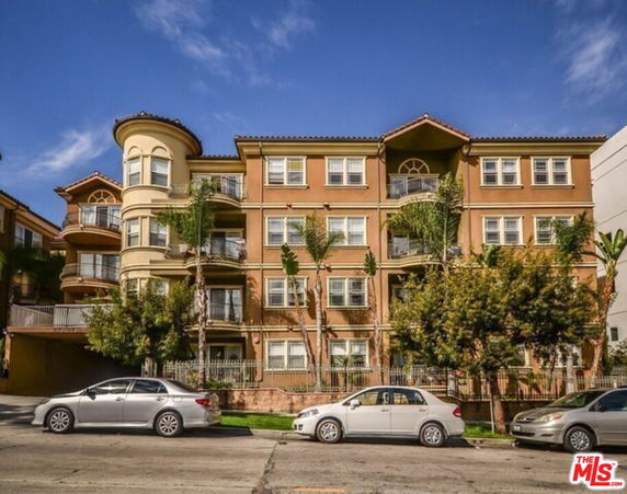 Front view of a multi-story apartment building with balconies.