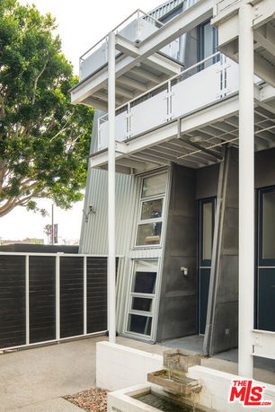 Front view of a modern multi-story building with metal and glass features.