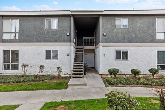 Front view of a two-story apartment building with exterior stairs.