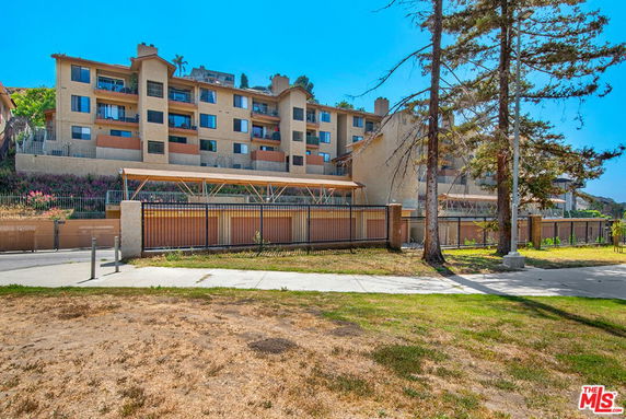 Front view of a multi-story apartment building with balconies.