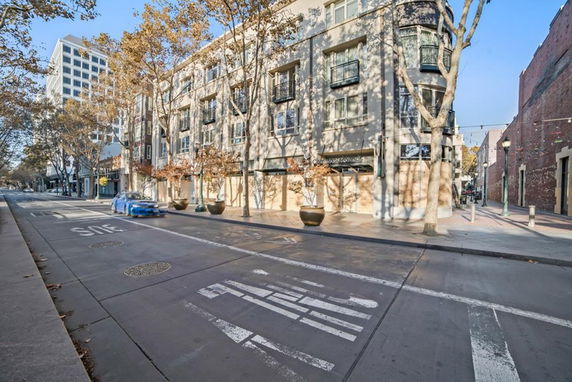 Front view of a multi-story building with large windows and a storefront on the ground floor.