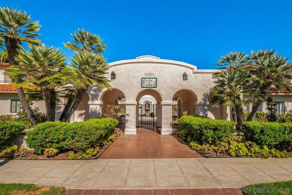 Front view of a building with an arched entrance and tiled walkway.
