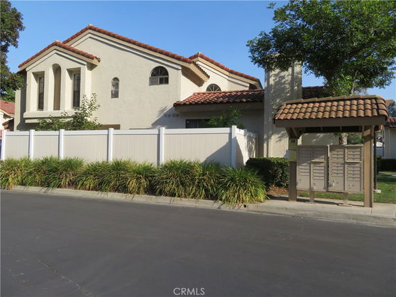 Front view of a two-story house with red-tiled roof and white exterior.