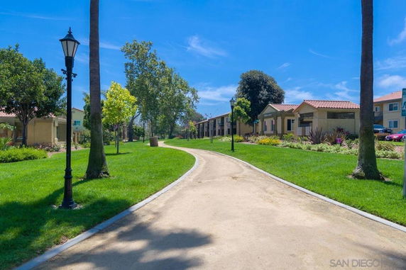 Pathway through a landscaped area with buildings and trees.
