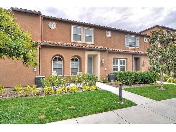 Front view of a two-story townhouse with arched windows and tiled roof.