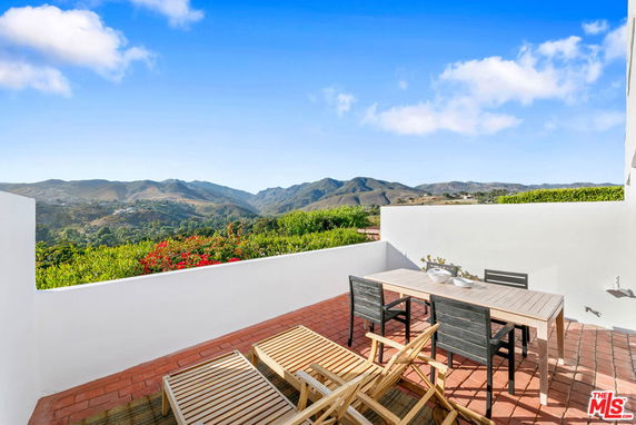 Outdoor patio with a view of surrounding mountains.