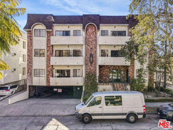 Front view of a multi-story residential building with a brick and stucco facade.
