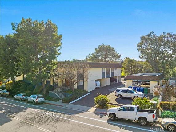 Front view of a multi-story building with parking in front.