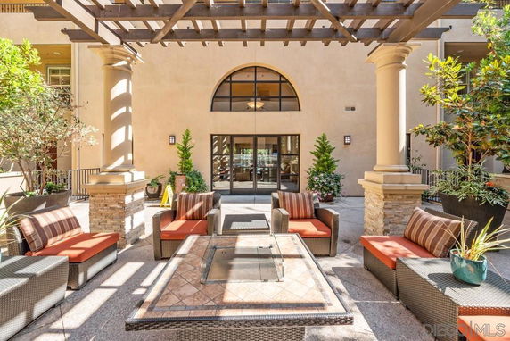 Outdoor patio with seating arrangement in front of a building entrance.