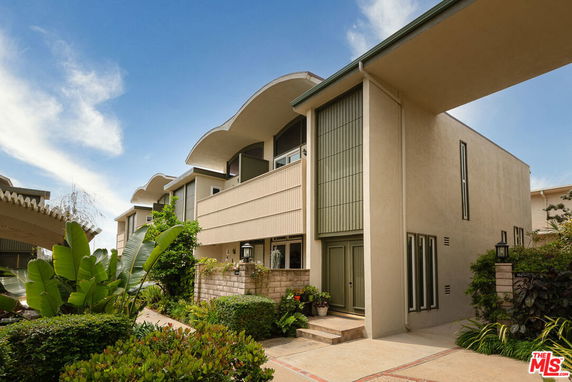 Front view of a modern multi-story building with unique roof design.