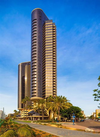 Front view of a tall modern skyscraper with rounded edges.