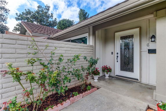 Front view of a house with a decorative glass door and small garden.