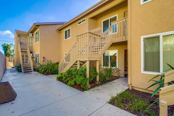 Front view of a two-story apartment building with exterior staircases.
