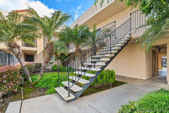 Front view of a two-story apartment building with an external staircase.