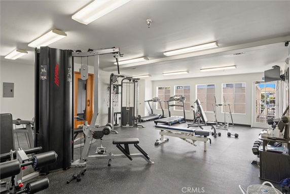 Interior view of a gym with exercise equipment and large windows.