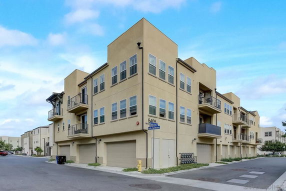 Front view of a multi-story residential building with balconies and garages.