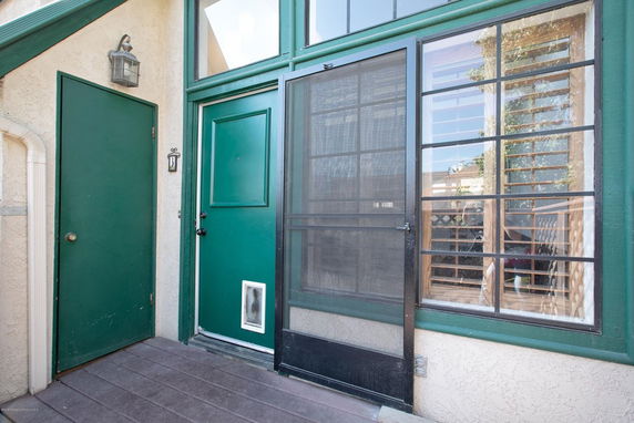 Front entry view of a building with green doors and window.