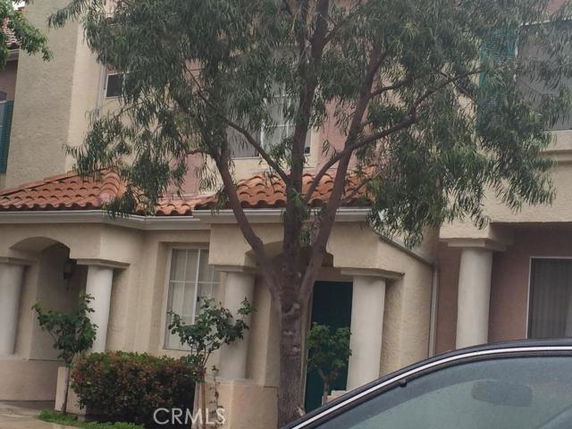 Front view of a two-story house with a tile roof and columns.