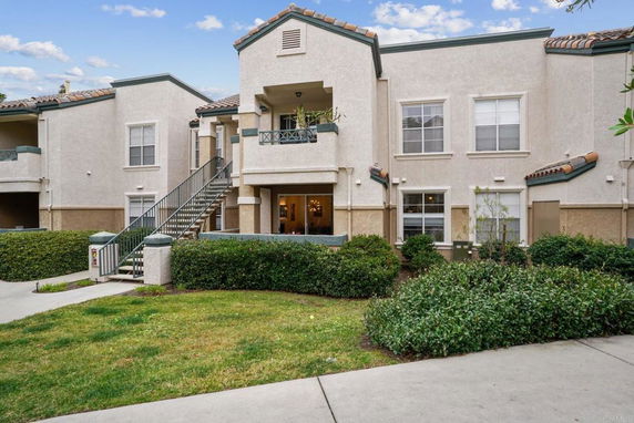 Front view of a two-story residential building with outdoor staircase.