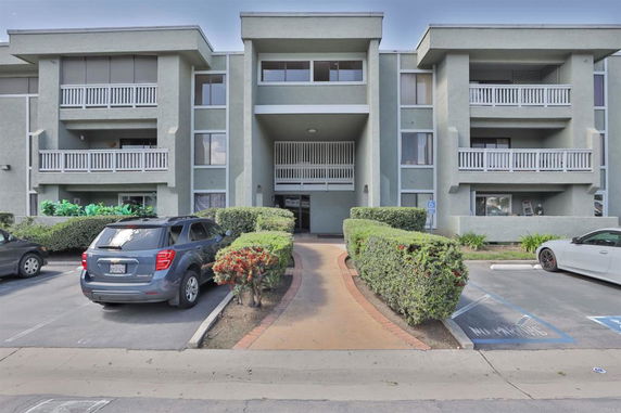Front view of a multi-story residential building with balconies.
