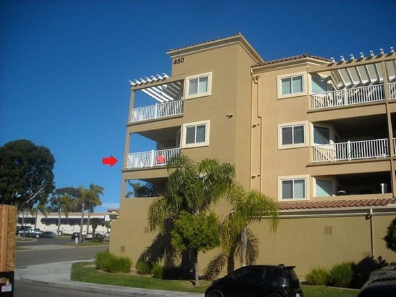 Front view of a multi-story apartment building with balconies.