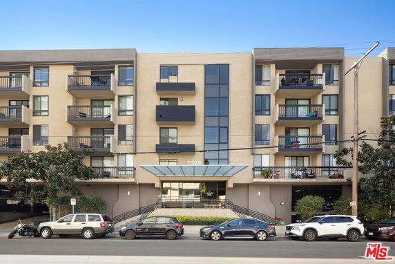 Front view of a multi-story apartment building with balconies.