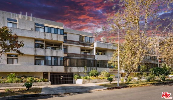 Front view of a multi-story apartment building with multiple balconies.