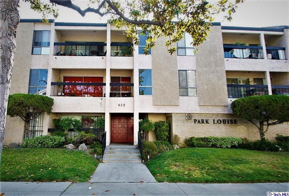 Front view of a multi-story apartment building with balconies.