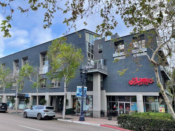 Front view of a multi-story commercial building with a coffee shop on the ground floor.