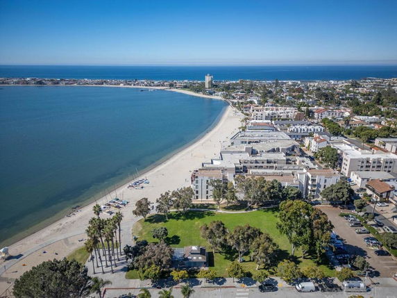 Wide angle view of beachfront area with residential buildings along the shoreline.
