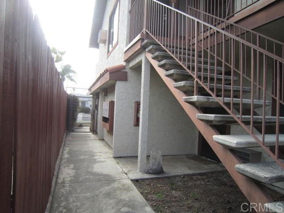 Side view of a multi-story building with stairs leading to the upper level.