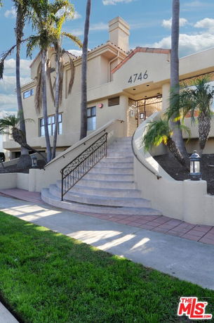 Front view of a multi-story building with staircase entrance.