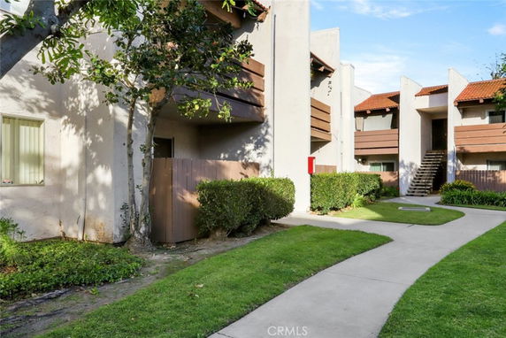 Front view of a multi-unit residential building with beige walls and brown accents.