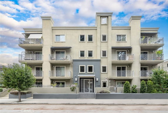 Front view of a multi-story apartment building with multiple balconies.
