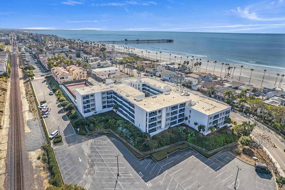 Aerial view of a coastal building complex with surrounding beach and ocean.