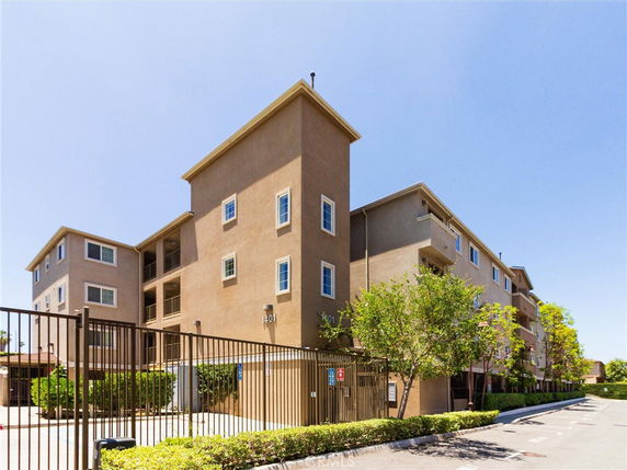 Front view of a multi-story apartment building with a gated entrance.