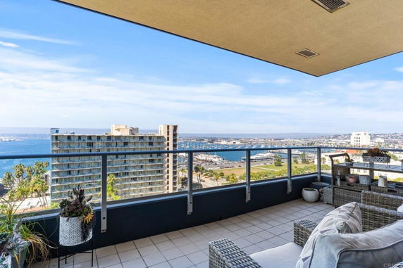 View from a balcony overlooking a cityscape and body of water.