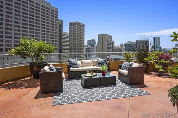 Rooftop patio with outdoor seating and city view.
