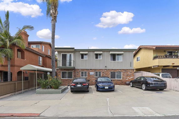 Front view of a two-story building with parking spaces in front.
