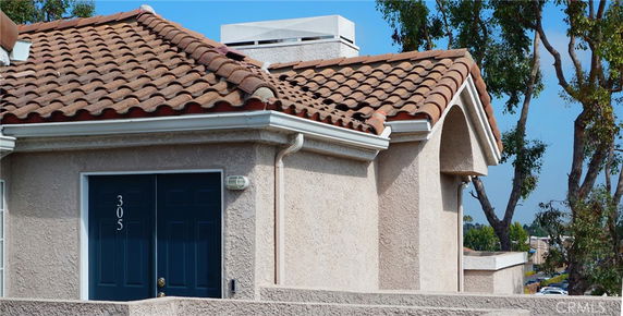 Front view of a house with a tiled roof and a blue door.