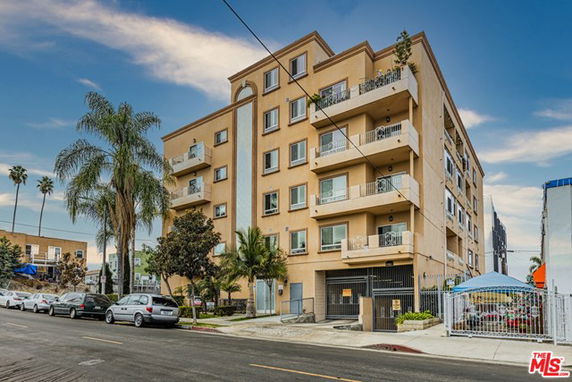 Front view of a multi-story apartment building with balconies.