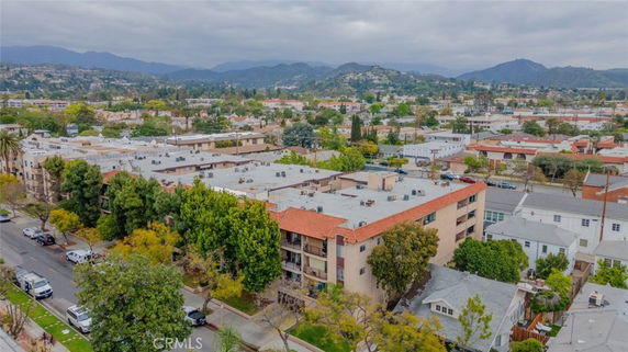 Aerial view of buildings and surrounding areas with mountains in the background.