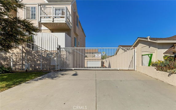 Front view of a multi-story building with a gated driveway.