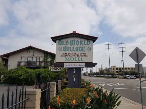 Front view of a building with a large sign for Old World Village Motel.