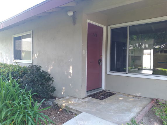 Front view of a single-story house with a covered entryway and a large window.